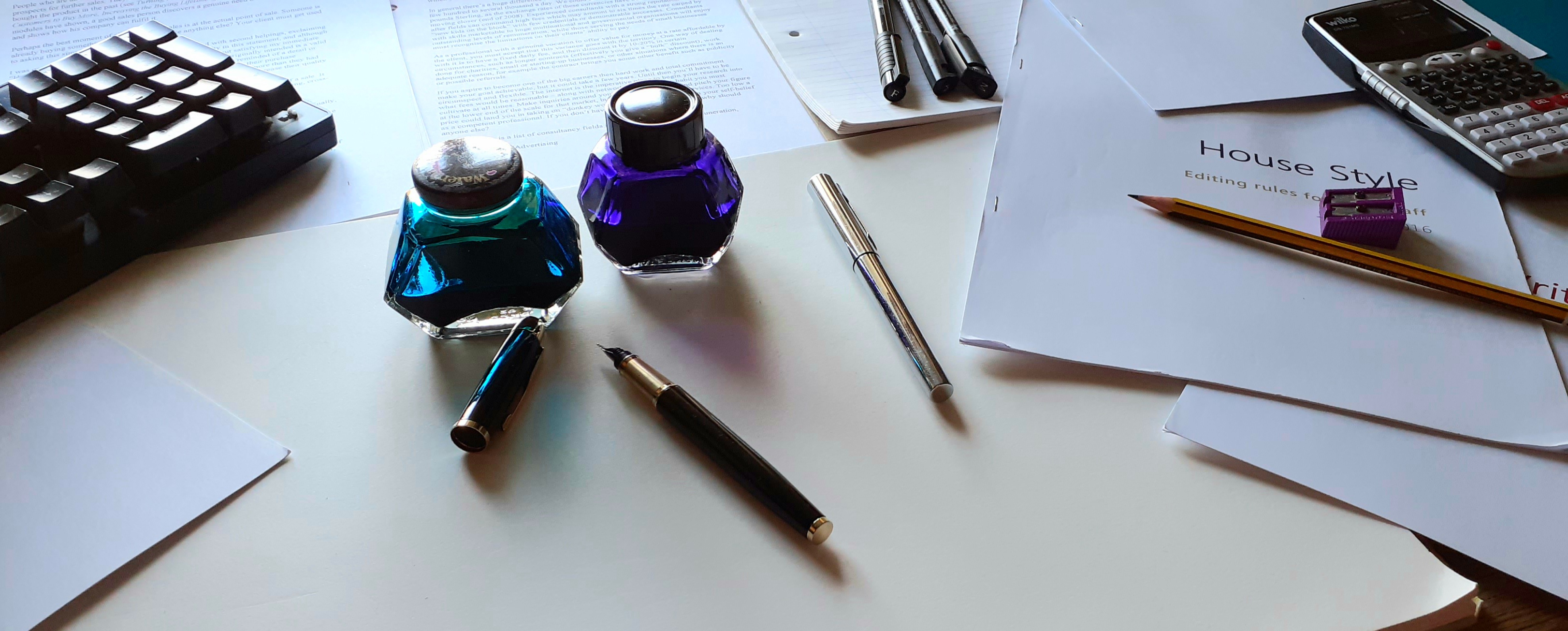 A desk with pens and ink bottles